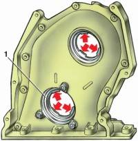 —3. Крышка привода распределительного вала с держателем (1) переднего сальника коленчатого вала. Стрелками указаны выступы для центрирования держателя и крышки относительно коленчатого вала и валика привода масляного насоса